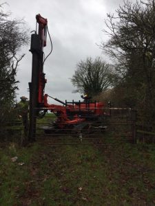 Fifteen feet long telegraph pole for a gate post being driven in to hang a gate on at Poulshot